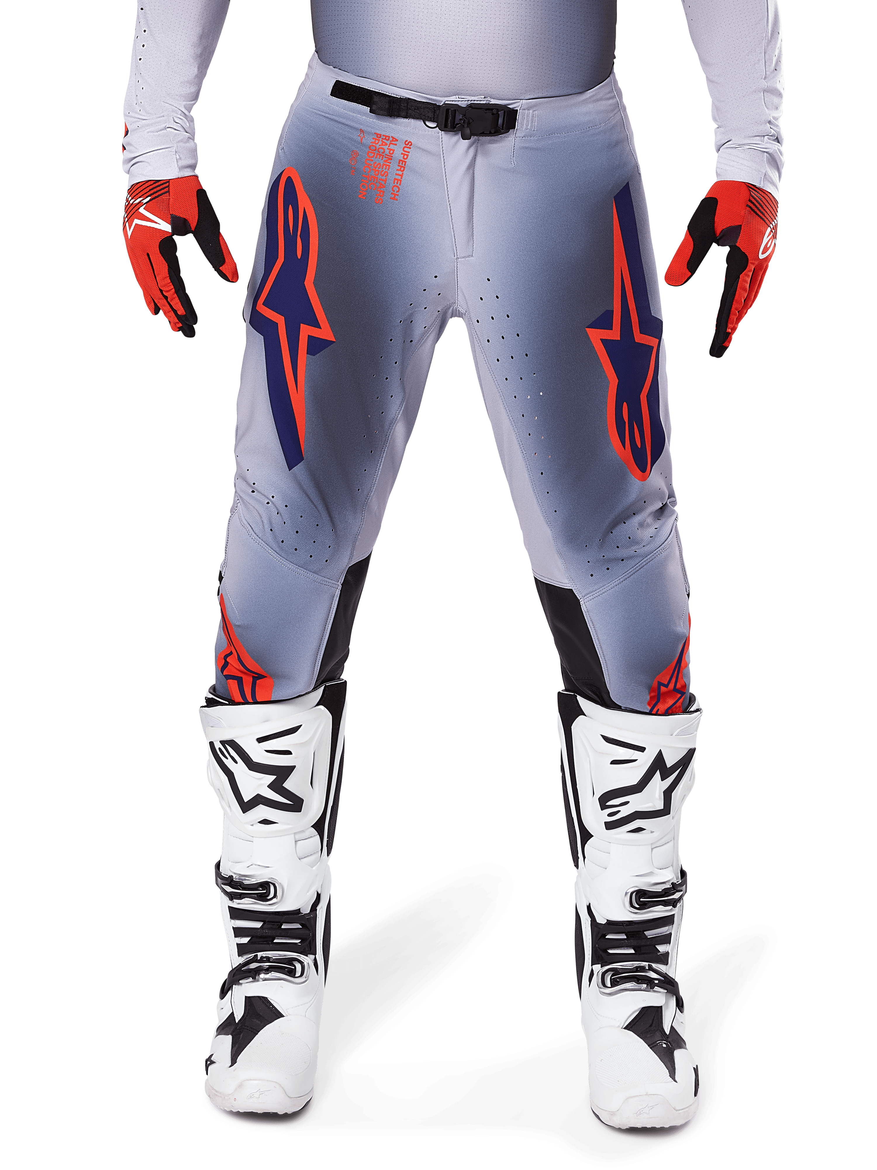 Alpinestars 2025 Supertech Lipan Pants, Motocross Pants, Gray and Orange Fluo, worn with red and black gloves and white and black boots, featuring large Alpinestars star logos on the thighs and ventilation perforations for pro-level racing.