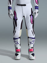 Alpinestars 2026 Supertech AFD Vista Hose, Motocross-Hose, Weiß, Lila und Schwarz, getragen mit passenden weißen Stiefeln und Handschuhen, mit pink-lila Astars-Logos im Farbverlauf auf den Oberschenkeln, professionelles Renndesign für Offroad-Performance.