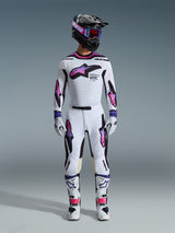 Motocross-Fahrer in kompletter Rennausrüstung, Alpinestars 2026 Supertech AFD Vista Hose und Trikot in Weiß, Lila und Schwarz, passende Handschuhe, weiß-schwarze Stiefel, schwarzer Helm mit lila Goggles, schlanke athletische Passform für Offroad-Performance