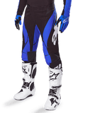 Alpinestars 2025 Techstar Dreem Pants, Motocross Pants, Black and Blue, worn with white motocross boots and blue gloves, featuring white Alpinestars logo on the leg, durable construction for off-road racing