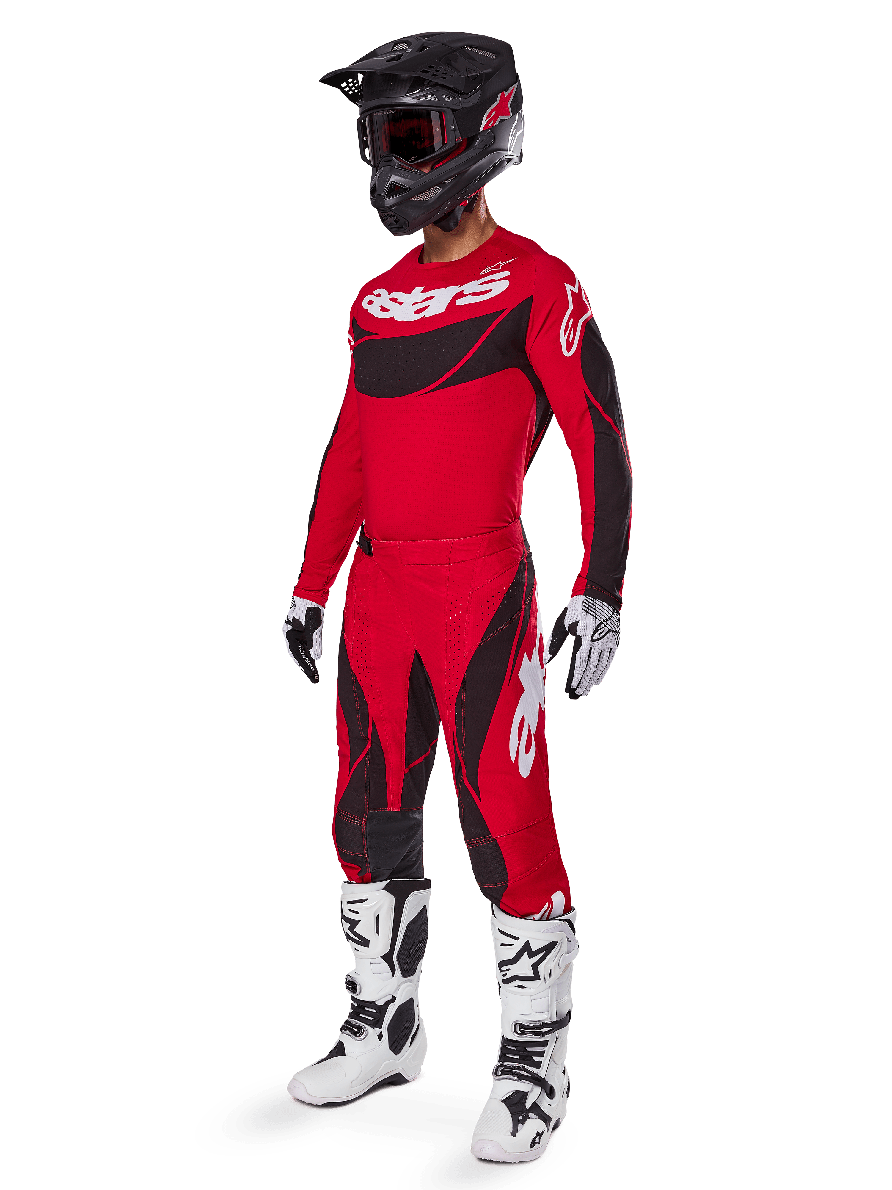 Motocross rider wearing complete racing gear featuring Alpinestars 2025 Techstar Dreem Pants in Bright Red and Black, matching red and black jersey with white logo, black helmet, and white and black boots, coordinated outfit for off-road racing