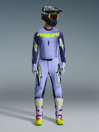 Alpinestars 2026 Supertech Scenz Pants, Motocross Pants, Purple Yellow Fluo, worn as a complete racing gear set with matching lavender jersey, gloves, and boots, featuring bold yellow fluo logos, athletic fit design for professional off-road racing.