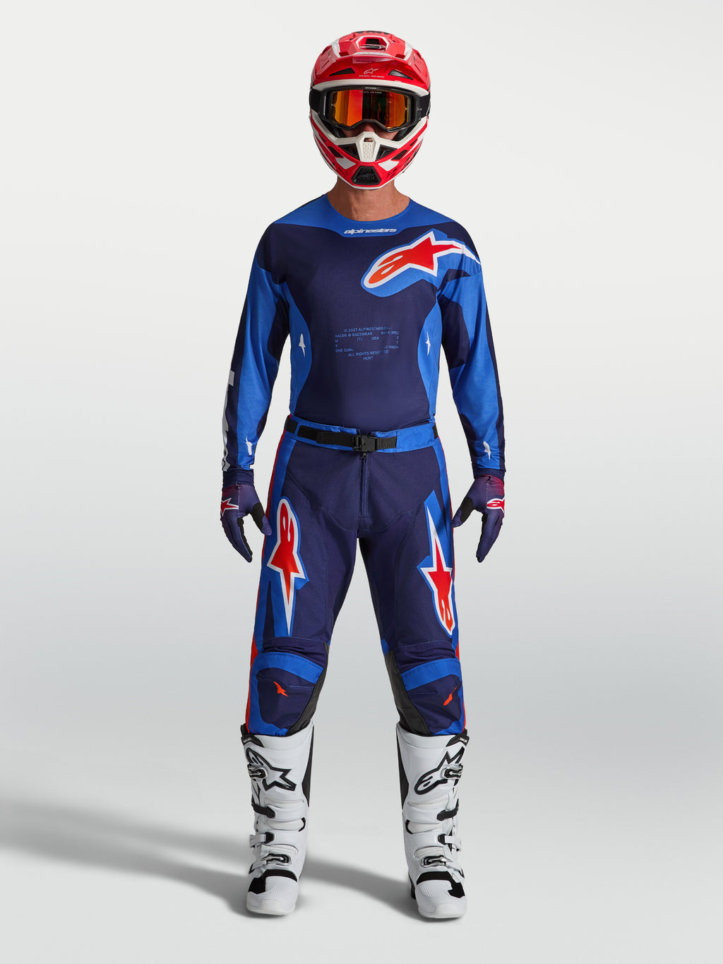 Alpinestars Racer Hunt Hose, Herren Motocross-Hose in Blau und Rot, strapazierfähige 600D-Polygewebe-Konstruktion, getragen von einem Model mit passender MX-Ausrüstung.