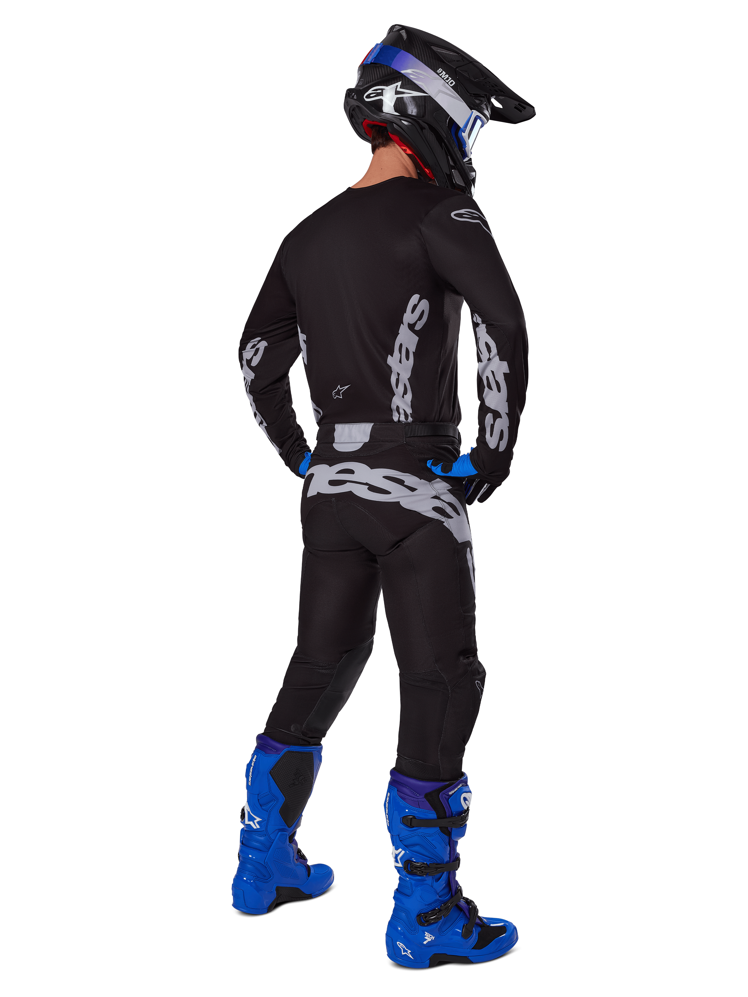 Alpinestars 2025 Racer Graphite Pants, Motocross Pants, Black and Gray, back view of a rider in a full gear set with a matching jersey and bright blue boots, featuring large gray branding on the seat and an ergonomic pre-curved design for off-road racing.
