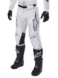 Alpinestars 2025 Racer Hollow Hose, Motocross-Hose, Weiß und Grau Camouflage, mit großen schwarz umrandeten Stern-Logos und schwarzen Leder-Innenknie-Einsätzen, kombiniert mit schwarzen Motocross-Stiefeln und Handschuhen, strapazierfähiges Design für Offroad-Rennsport