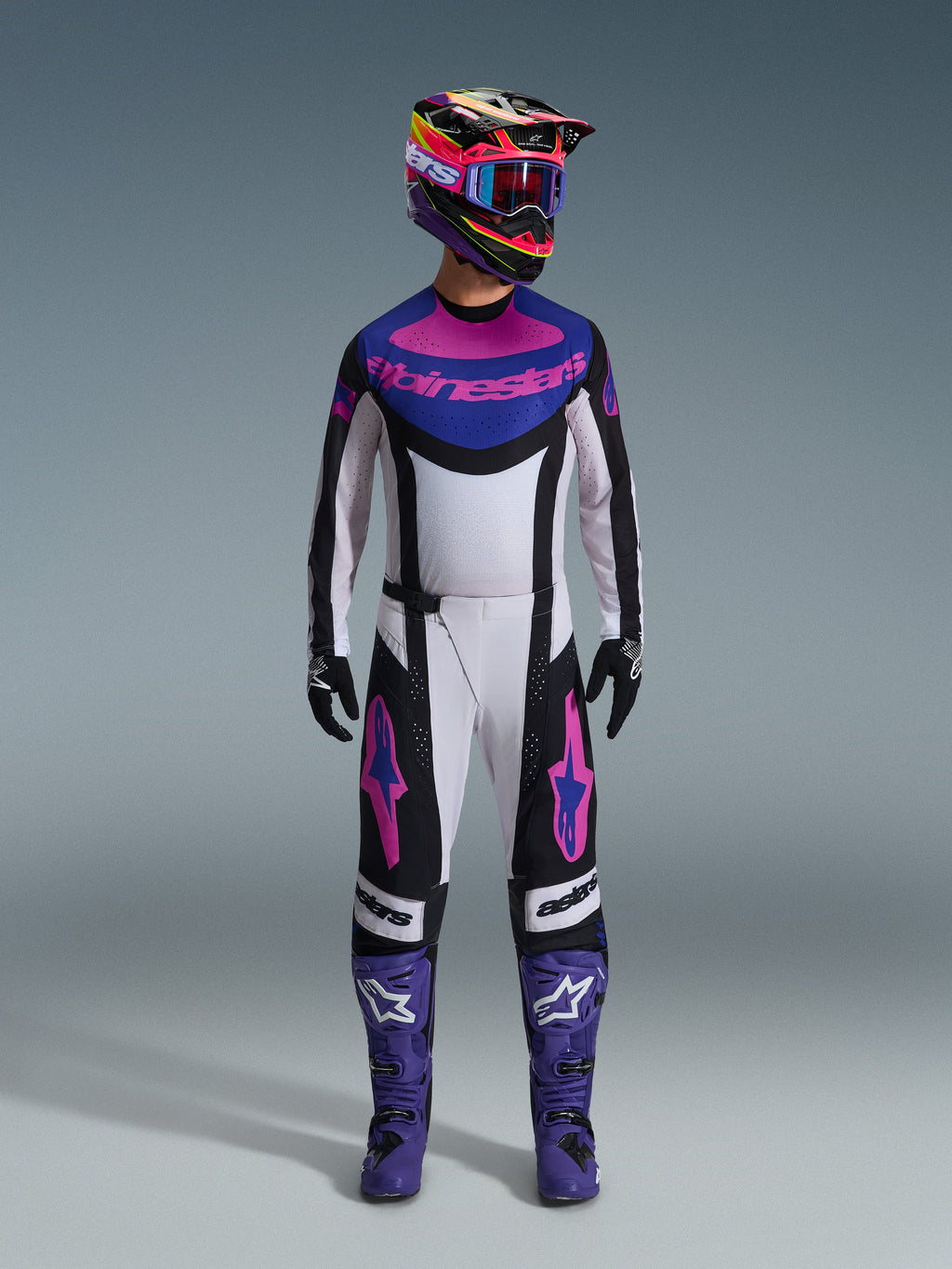 Alpinestars 2026 Techstar Knif Gear Set, Motocross-Komplettausrüstung, Weiß, Schwarz, Lila und Pink, getragen mit einem mehrfarbigen Helm, blauer Brille, lila Stiefeln und schwarzen Handschuhen, abgestimmtes Hochleistungs-Set für den Offroad-Rennsport