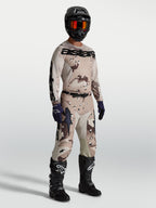 Alpinestars Racer Lone Gear Set, Motocross-Trikot und Hose in Braun Camouflage mit schwarzen Stiefeln und Helm.