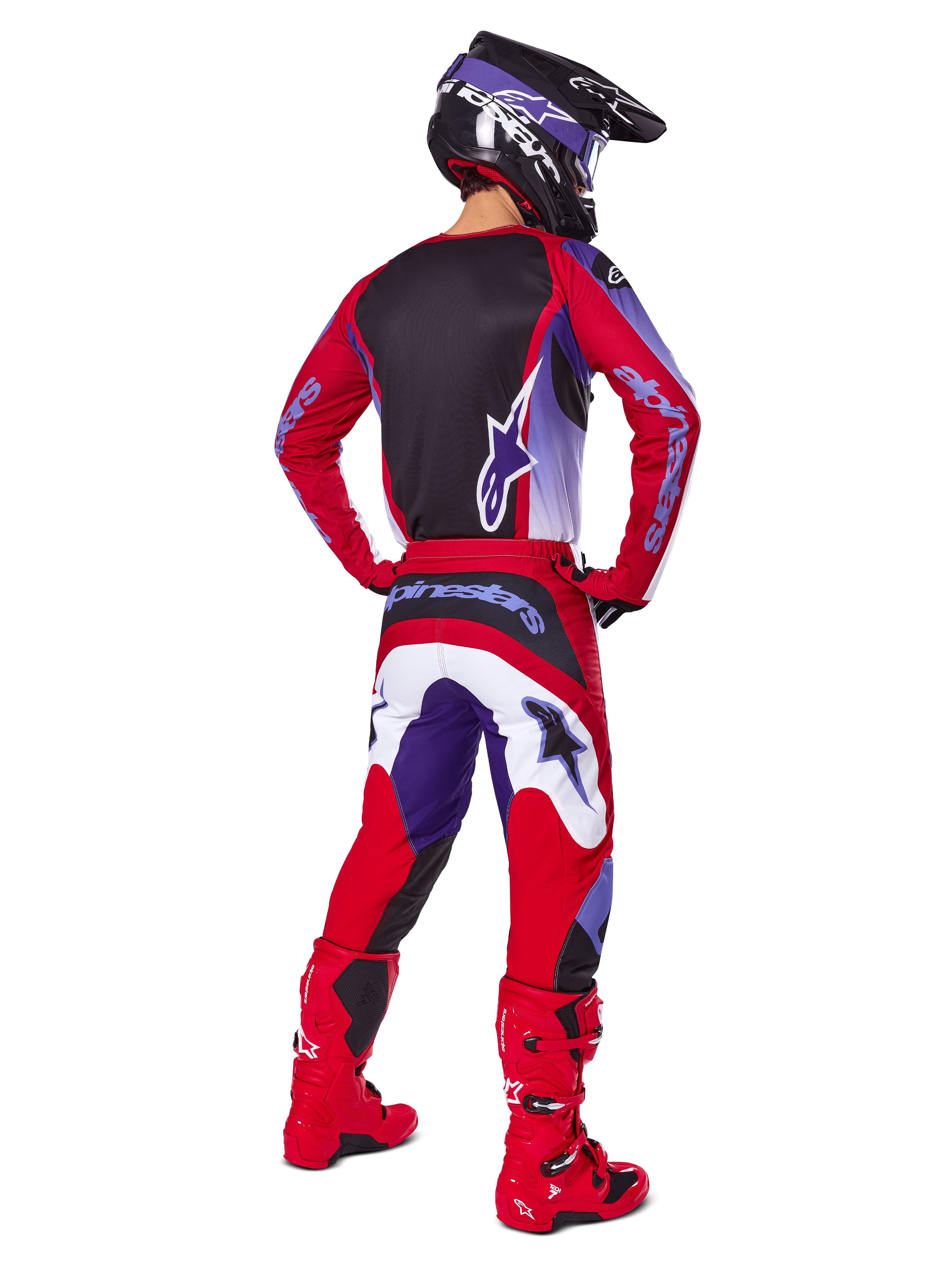 Motocross-Fahrer von hinten in Alpinestars 2025 Fluid Wurx Hose, Purple Bright Red mit weißen und schwarzen Akzenten, passendes Trikot, schwarzer Helm und rote Stiefel, abgestimmtes Outfit für den Offroad-Rennsport