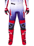 Alpinestars 2025 Fluid Wurx Hose, Motocross-Hose, Lila und Hellrot, getragen mit passenden roten Stiefeln und Handschuhen, mit weißen Logos auf den Oberschenkeln und schwarzen Knieverstärkungen, Performance-Ausrüstung für den Offroad-Einsatz