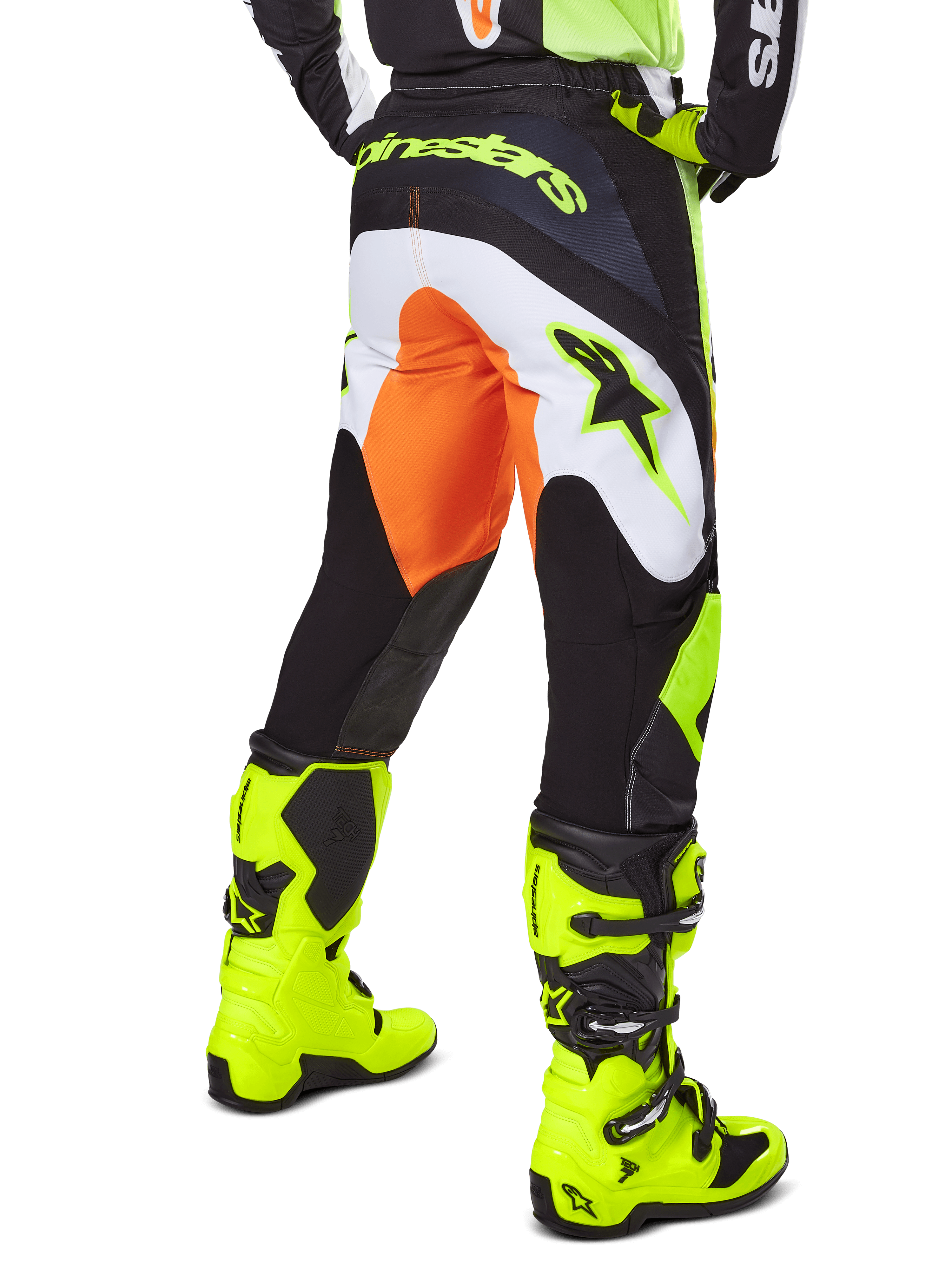 Alpinestars 2025 Fluid Wurx Hose, Motocross-Hose, Gelb und Schwarz mit orangefarbenen und weißen Akzenten, Rückansicht getragen mit passenden leuchtend gelben Stiefeln, strapazierfähige Konstruktion mit markantem Branding für das Dirtbike-Fahren