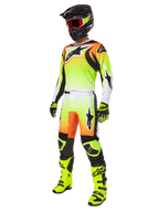 Motocross-Fahrer in Alpinestars 2025 Fluid Wurx Hose in Gelb und Schwarz, lebendiger Gelb-Weiß-Farbverlauf mit orangefarbenen und schwarzen Akzenten, Teil eines kompletten Rennausrüstungs-Sets mit passendem Trikot, schwarzem Helm und neongelben Stiefeln.