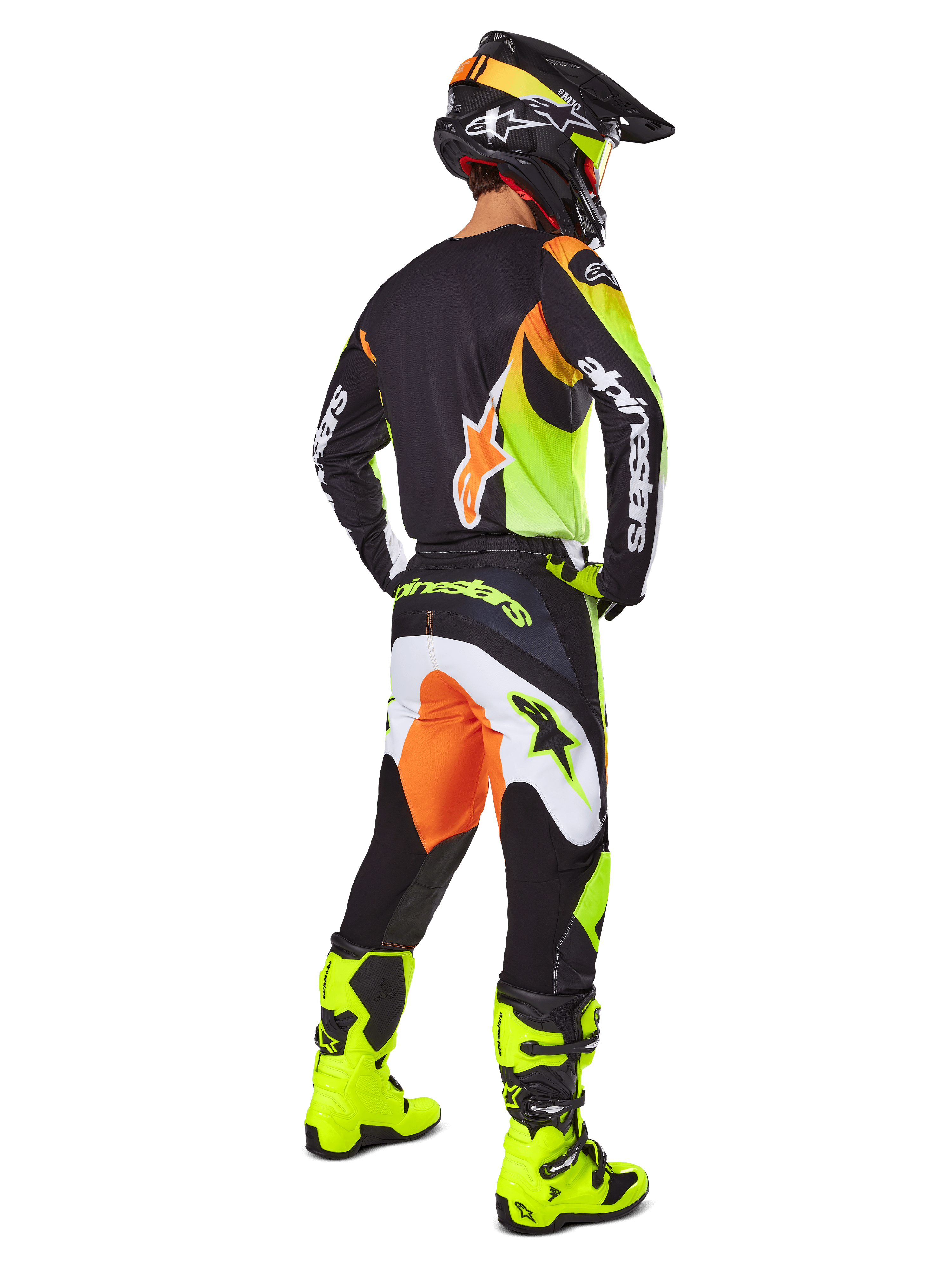 Motocross-Fahrer in der Rückansicht im Alpinestars 2025 Fluid Wurx Gear Set, schwarzes Trikot mit gelben und orangefarbenen Akzenten, passende schwarze Hose mit weißen und orangefarbenen Einsätzen, leuchtend gelbe Stiefel und schwarzer Helm, komplette Offroad-Rennausrüstung