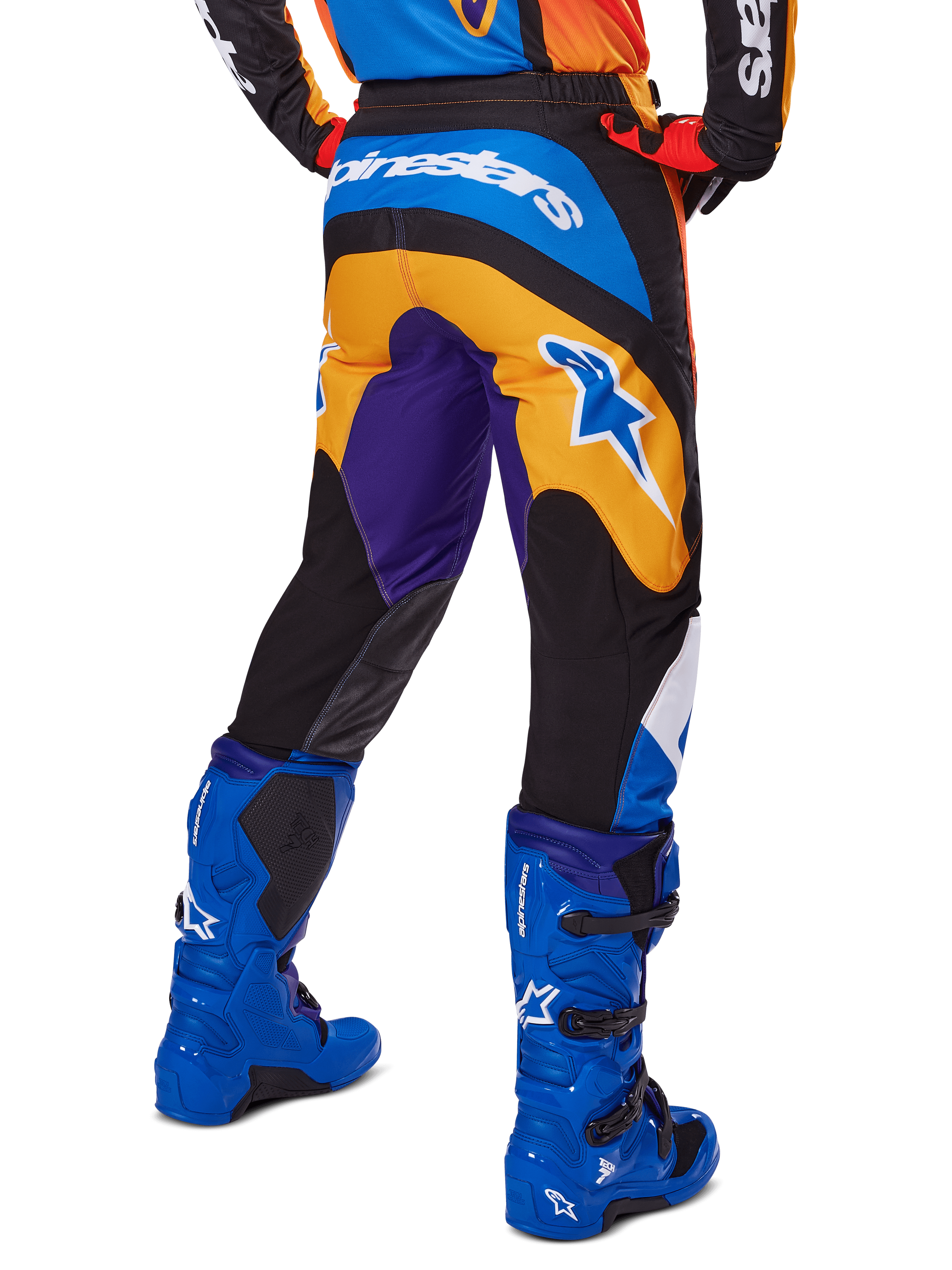 Alpinestars 2025 Fluid Wurx Pants, Motocross Pants, Multicolor with Orange, Purple, and Blue, rear view showing white Alpinestars logo on the back, paired with blue motocross boots, athletic fit for off-road racing.