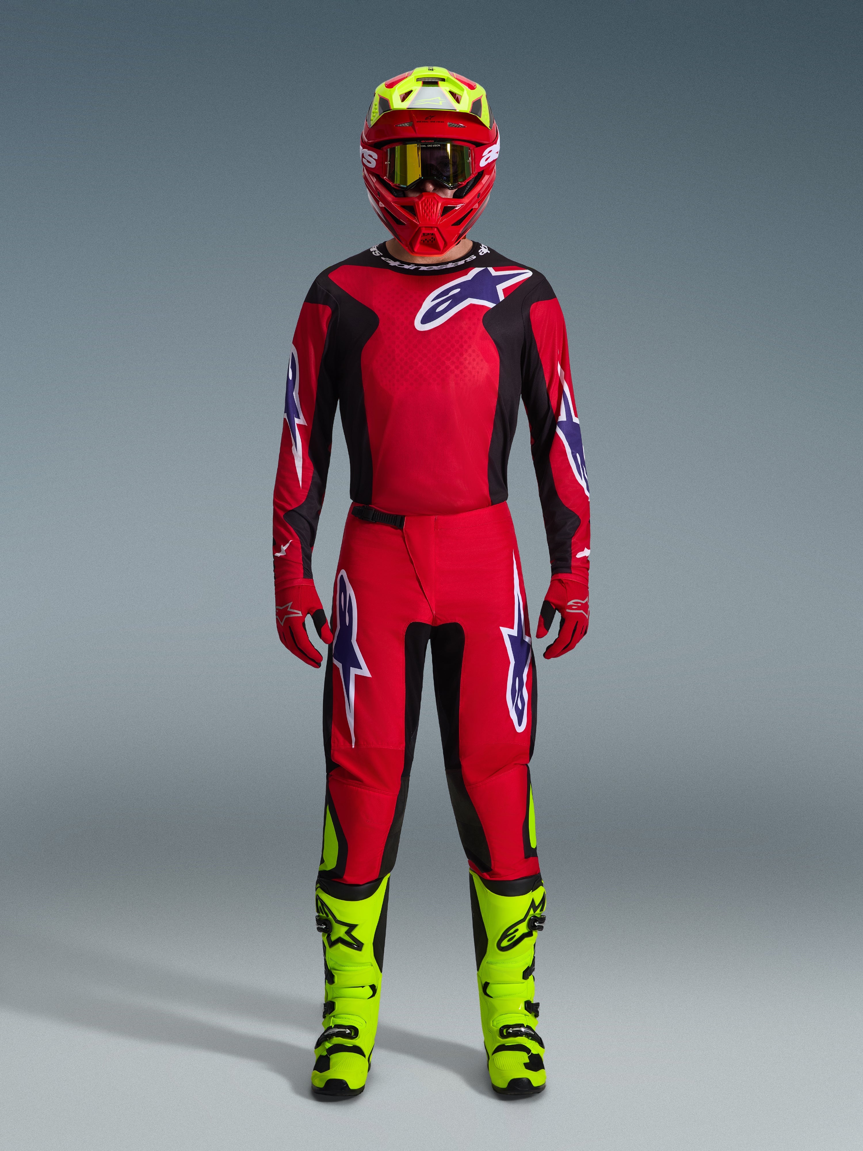 Alpinestars 2026 Fluid Grid Gear Set, Motocross-Outfit, Rot und Schwarz, komplette Fahrausrüstung mit rotem Jersey und Hose mit blau-weißen Logos, passender roter Helm mit neongelben Akzenten und neongelbe Stiefel, Hochleistungsdesign für den Offroad-Rennsport
