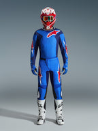 Motocross-Fahrer in Alpinestars 2026 Fluid Grid Hose in Blau und Rot, passendes blaues Trikot mit rotem Astars-Logo, rot-weißer Helm mit Brille, blaue Handschuhe und weiße Motocross-Stiefel, komplett abgestimmte Offroad-Rennausrüstung