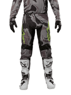 Alpinestars 2024 Racer Tactical Hose, Motocross-Hose, Cast Gray Camo Magnet, getragen mit passendem Camo-Trikot, schwarzen Handschuhen und weiß-schwarzen Stiefeln, mit neongrünen Stern-Logos auf den Oberschenkeln und schwarzen Stretch-Paneelen, Vorderansicht der Offroad-Fahrausrüstung