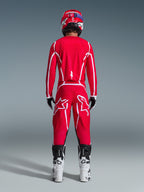 Alpinestars 2026 Fluid Apex Hose, Motocross-Hose, Rot und Weiß, Rückansicht getragen mit passendem Trikot, rotem Helm und weiß-schwarzen Stiefeln, mit großen weißen Astar-Logos auf den Beinen, abgestimmtes Outfit für den Offroad-Rennsport