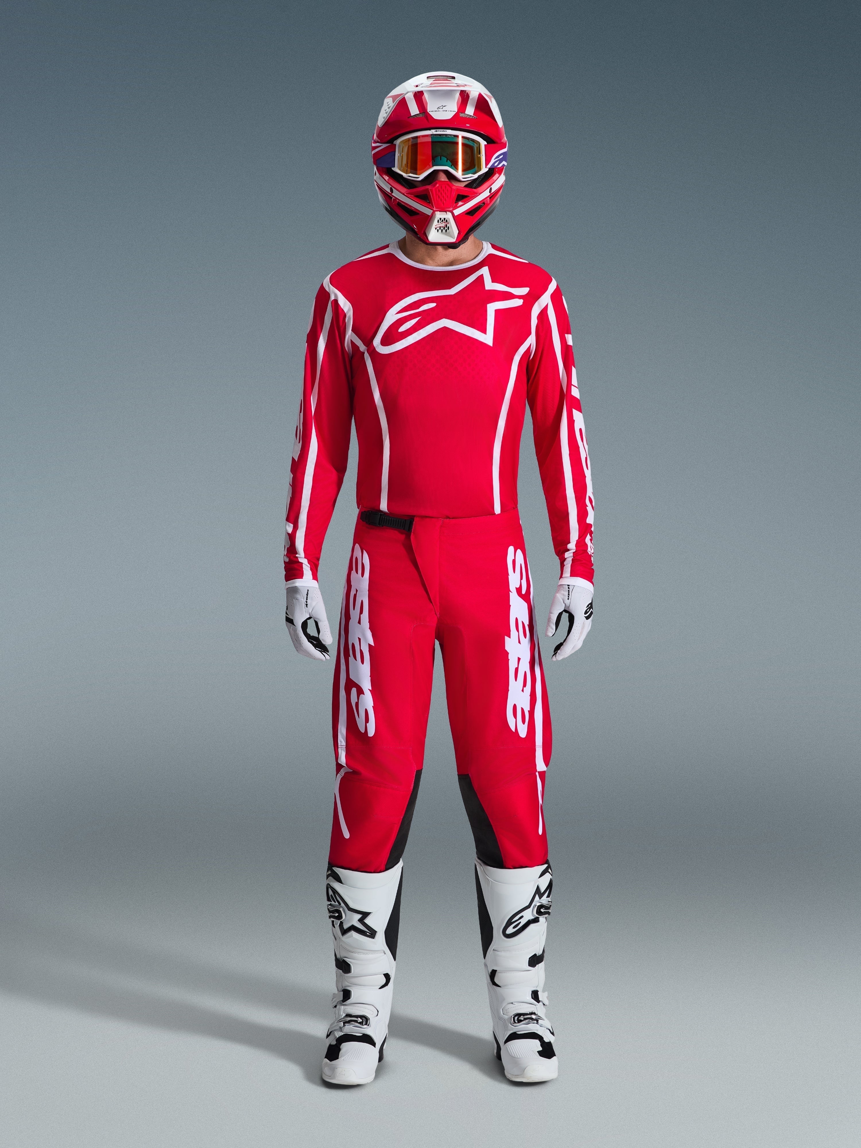Alpinestars 2026 Fluid Apex Hose, Motocross-Hose, Rot und Weiß, getragen als komplettes Rennausrüstungs-Set mit passendem rotem Jersey, weißen Stiefeln und rot-weißem Helm, mit markantem Branding und schwarzen Einsätzen für Offroad-Performance.