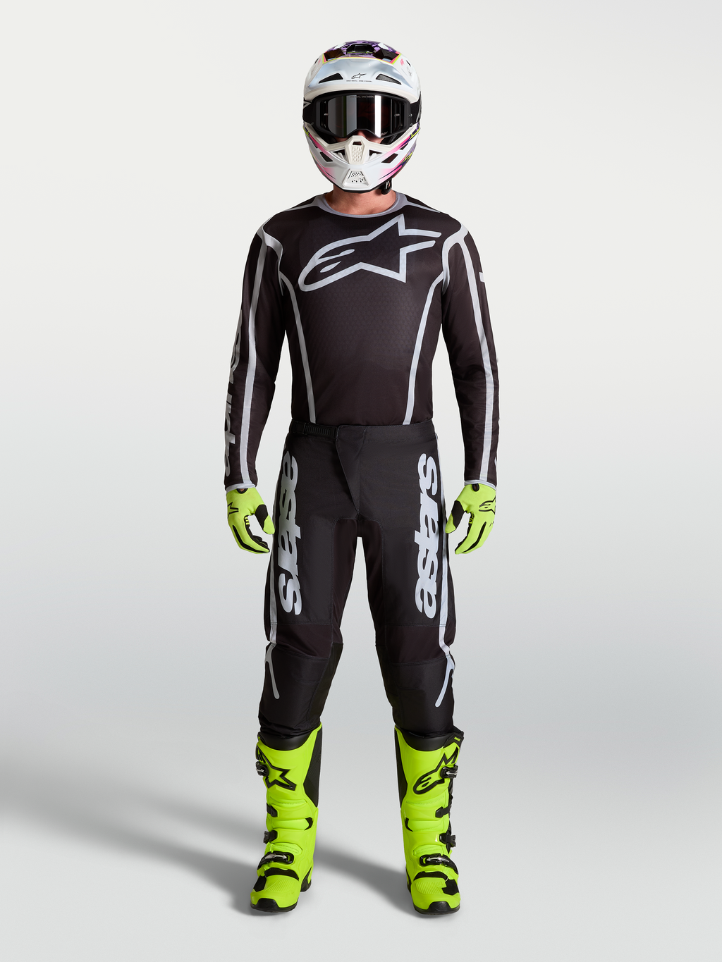 Alpinestars Fluid Apex V2 Hose, Motocross-Hose für Herren, Schwarz und Silber, Teil einer kompletten MX-Ausrüstung mit neongelben Motocrossstiefeln, Helm und Renntrikot.