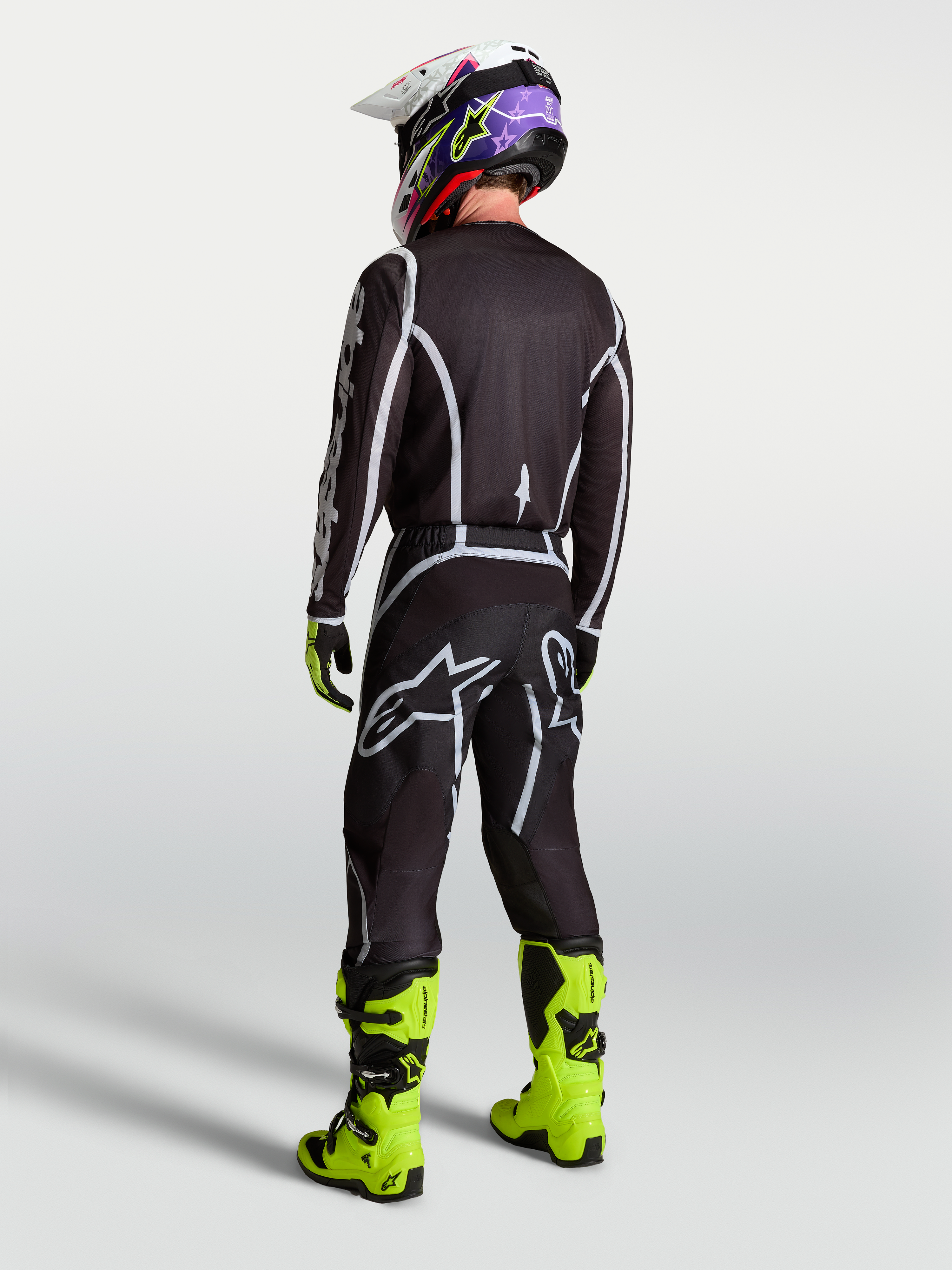 Alpinestars Fluid Apex V2 Hose, Motocross-Hose, Herren, Schwarz und Silber, R%fcckansicht mit Trikot und neongelben Stiefeln.