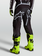 Alpinestars Fluid Apex V2 Hose, Motocross-Hose für Herren, Schwarz und Silber, getragen mit neongelben Motorradstiefeln, Offroad-Ausrüstung für MX-Fahrer.