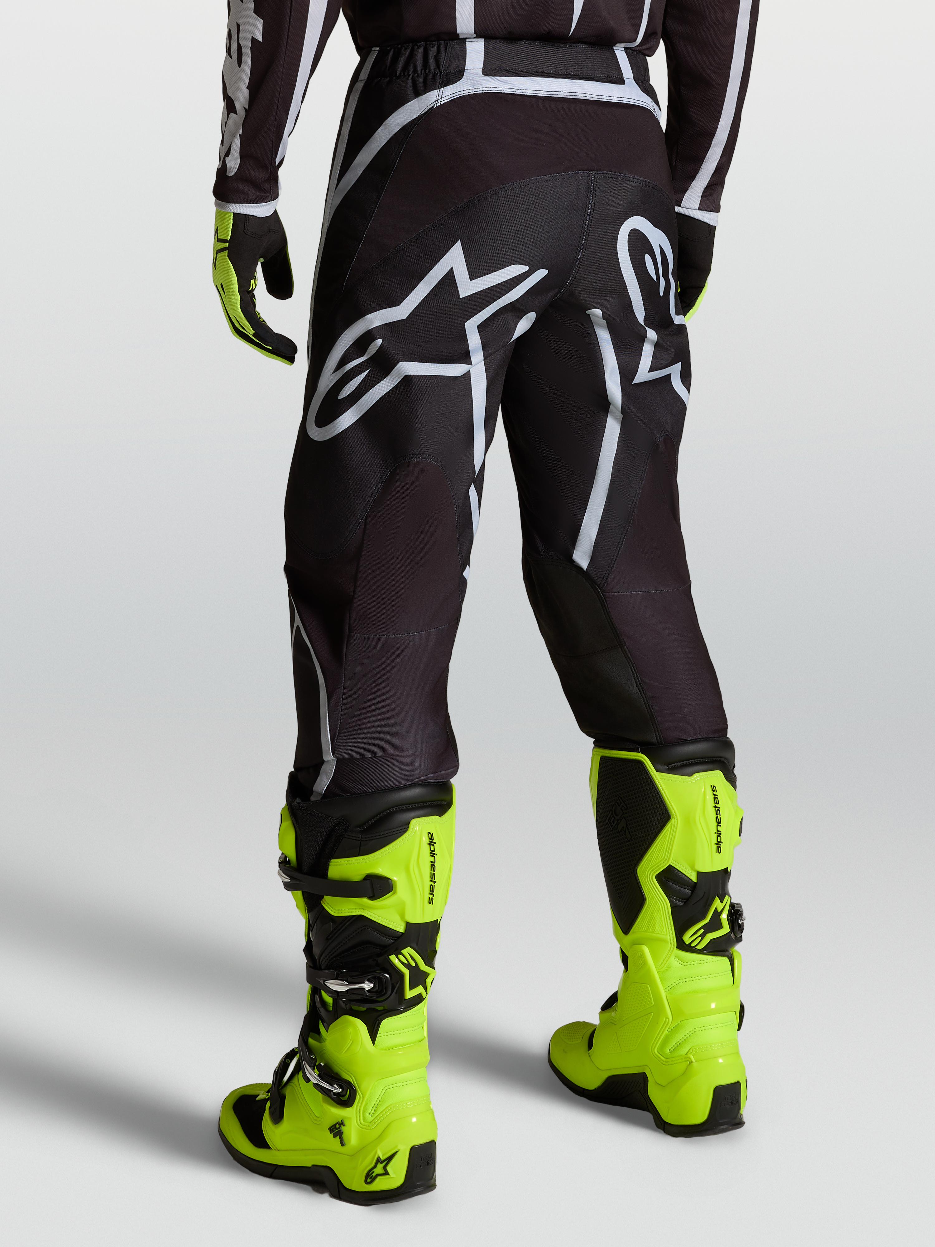 Alpinestars Fluid Apex V2 Hose, Motocross-Hose für Herren, Schwarz und Silber, getragen mit neongelben Motorradstiefeln, Offroad-Ausrüstung für MX-Fahrer.