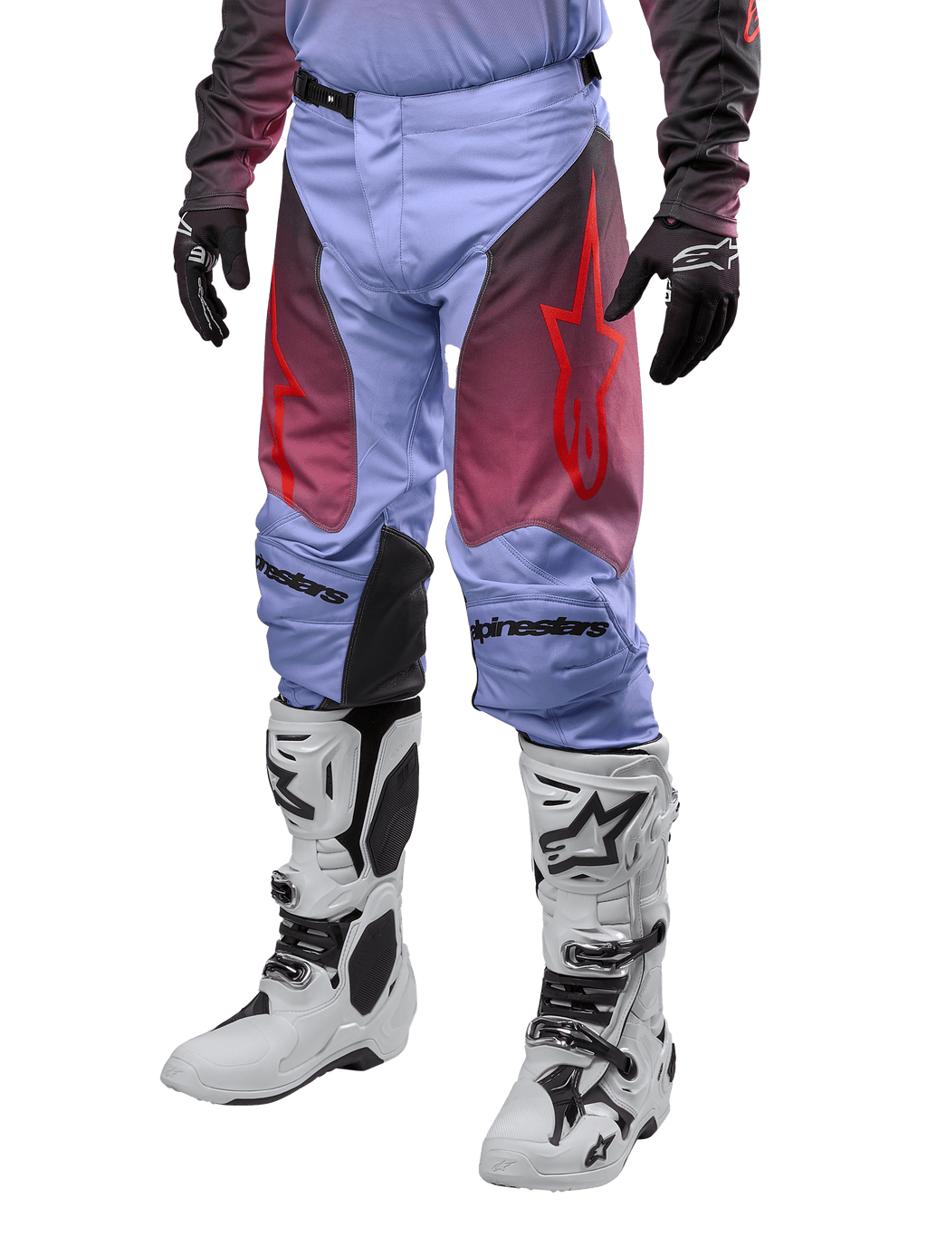 Alpinestars 2024 Racer Hoen Hose, Motocross-Hose, Lavan-Lila und Schwarz mit roten Grafiken, rote Stern-Logos auf den Oberschenkeln und schwarzer Schriftzug an den Knien, getragen mit weiß-schwarzen Stiefeln und schwarzen Handschuhen