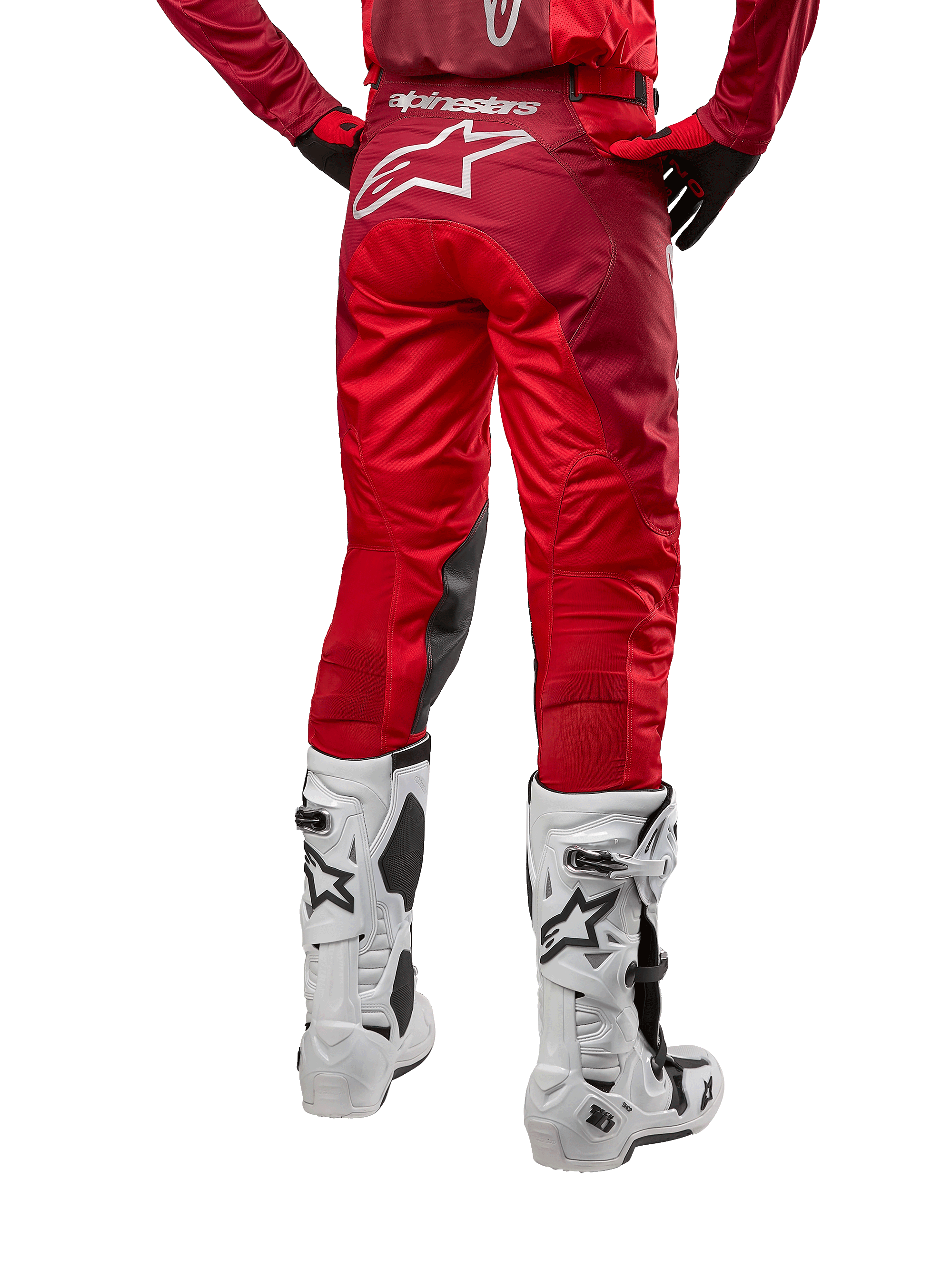 Alpinestars 2024 Racer Hoen Hose, Motocross-Hose, Mars Red Burgundy, Rückansicht mit großem weißem Astar-Logo auf der Rückseite, schwarze Knie-Innenpaneele, getragen mit weißen Motocross-Stiefeln, Hochleistungs-Offroad-Ausrüstung