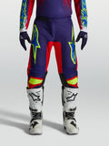 Alpinestars Fluid Drag Hose, Herren-MX-Hose in Blau und Rot, sportliche Passform, am Model mit Motocross-Stiefeln gezeigt.