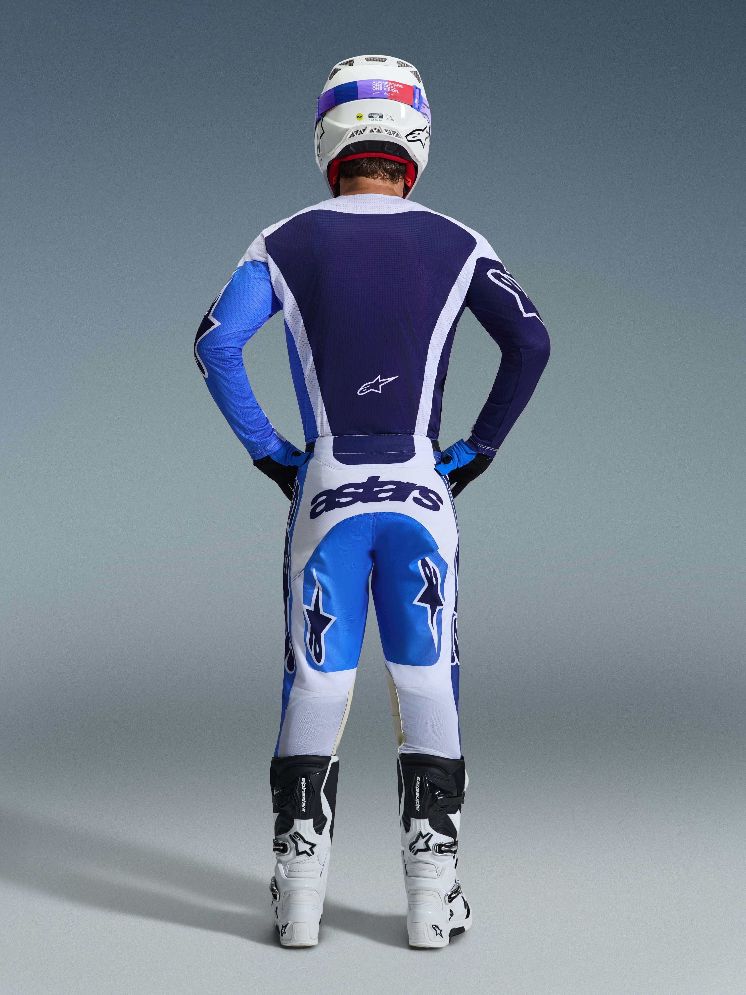 Alpinestars 2026 Racer Air Portl Pants, Motocross Pants, Ucla Blue White, rear view of rider wearing matching gear, white helmet, and white and black boots, featuring "astars" branding on the seat and star graphics on the legs, breathable design for off-road performance.