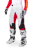 Alpinestars Limited Edition Techstar Deep Hose, Motocross-Hose, Weiß, Schwarz und High Red, getragen mit weißen und schwarzen Stiefeln und Handschuhen, mit weißen Frontpanels, roten Akzenten und schwarzen Seitendetails, entwickelt für High-Performance-Offroad-Rennsport
