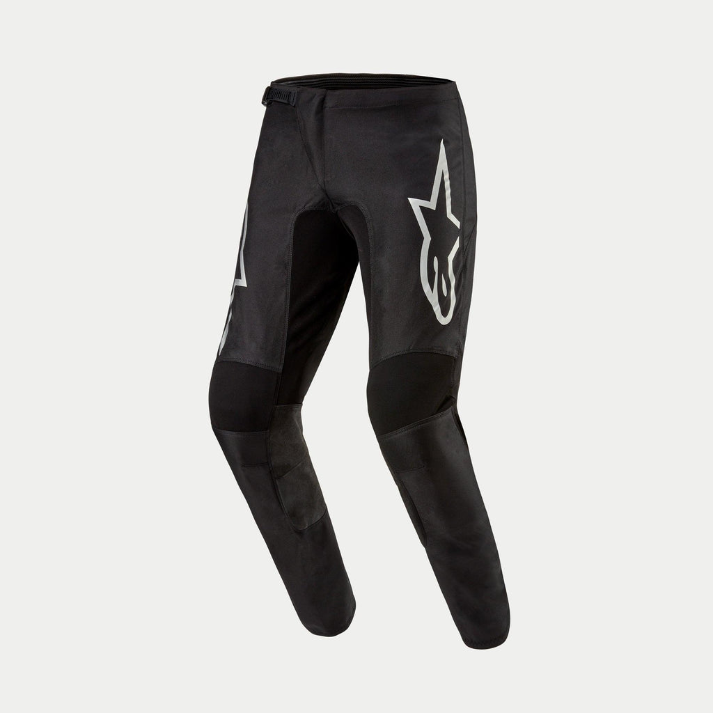 Alpinestars 2024 Fluid Graphite Pants, Motocross Pants, Black and Silver, featuring a large silver Astar logo on the thigh, black reinforced knee panels, and an ergonomic pre-curved design for off-road racing