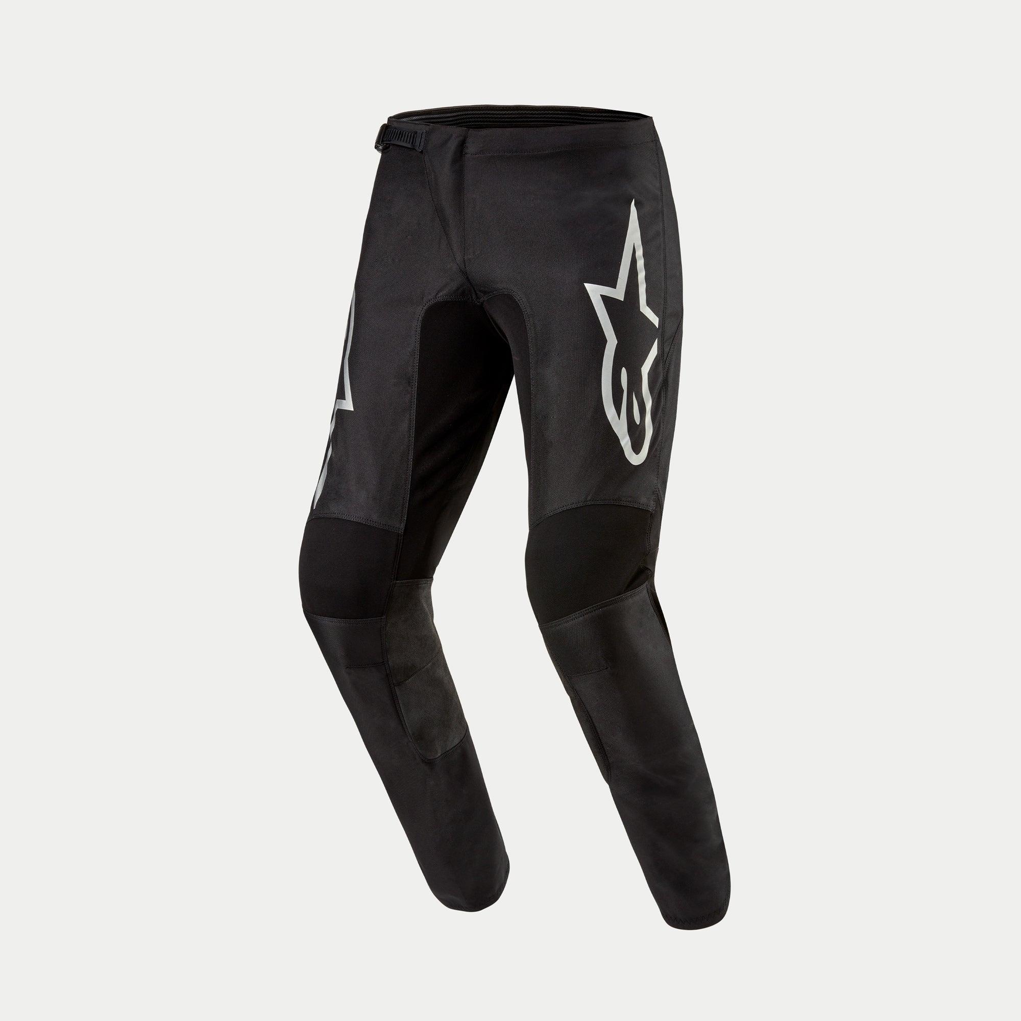 Alpinestars 2024 Fluid Graphite Pants, Motocross Pants, Black and Silver, featuring a large silver Astar logo on the thigh, black reinforced knee panels, and an ergonomic pre-curved design for off-road racing