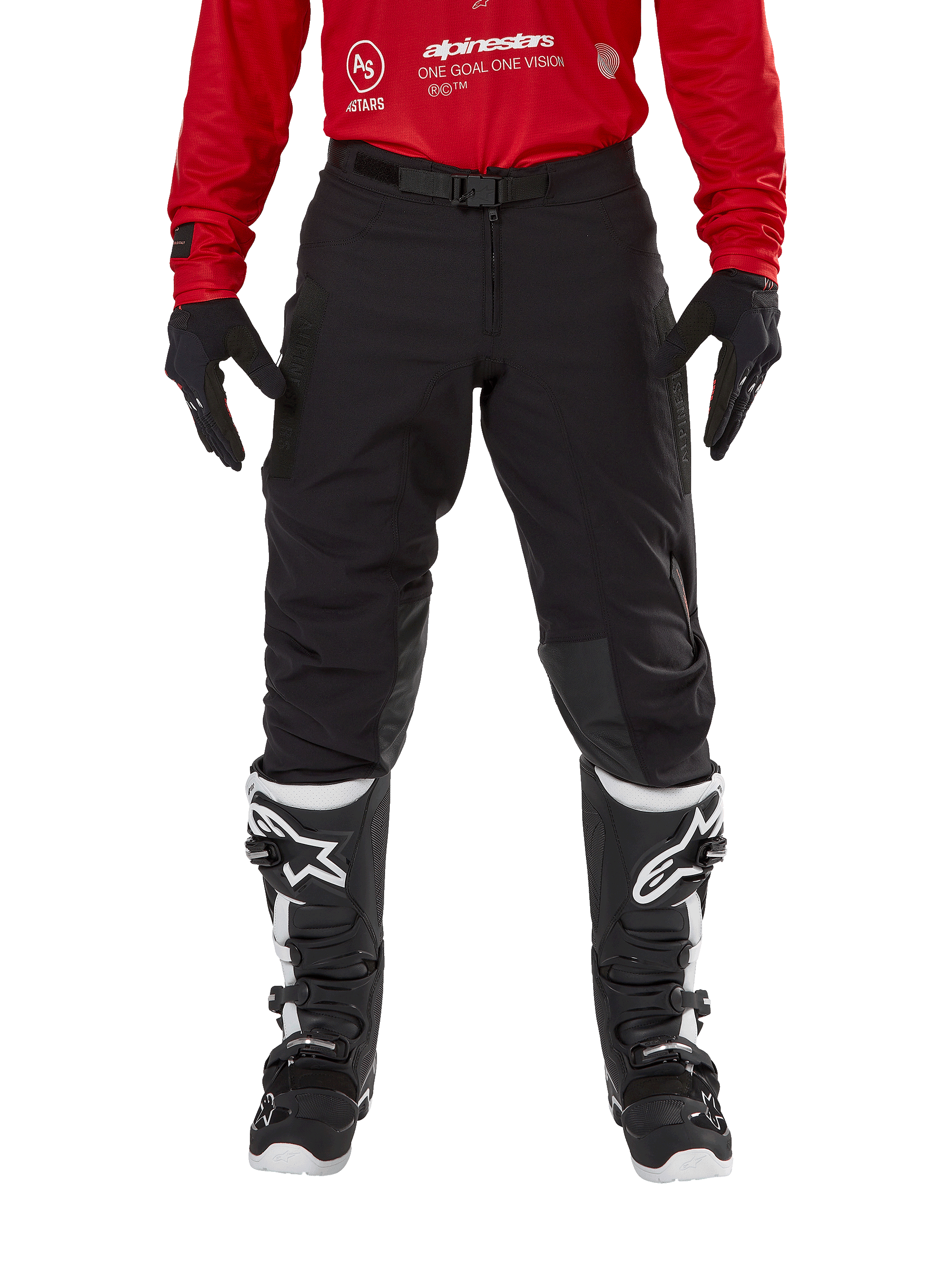 Alpinestars Techdura Hose, Enduro- und Offroad-Hose, Schwarz, getragen mit einem roten Alpinestars-Trikot und schwarz-weißen Stiefeln, mit robuster Stretch-Canvas-Konstruktion, verstellbarer magnetischer Gürtelschnalle und Knieverstärkungen aus Leder für Offroad-Performance.
