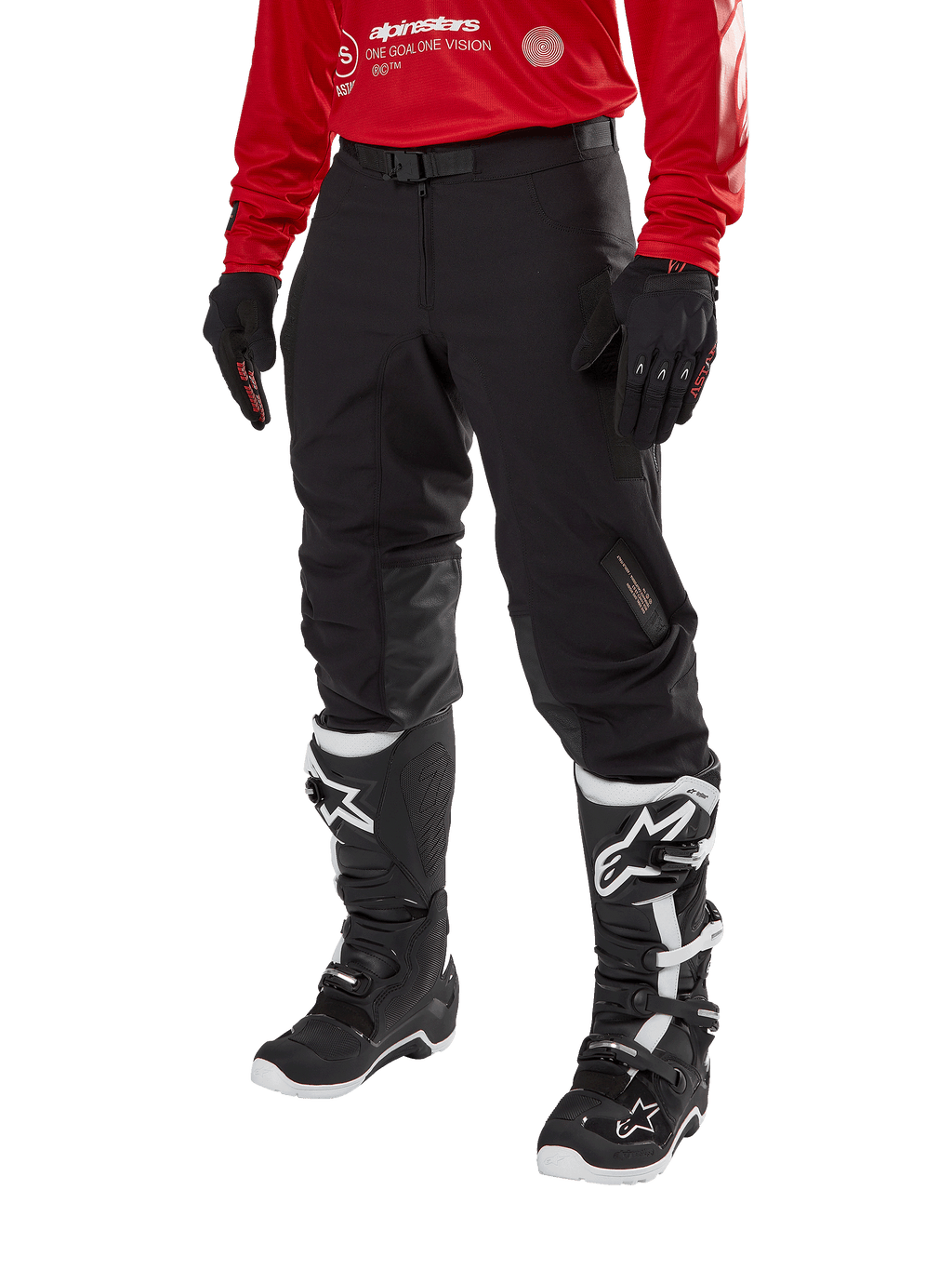 Alpinestars Techdura Hose, schwarze Offroad-Motorradhose, kombiniert mit einem roten Langarm-Trikot und schwarz-weißen Motocross-Stiefeln, mit robuster Stretch-Polyamid-Konstruktion, Lederverstärkungen an den Knieinnenseiten und einem verstellbaren Gürtel mit Schnalle für den Enduro-Einsatz.