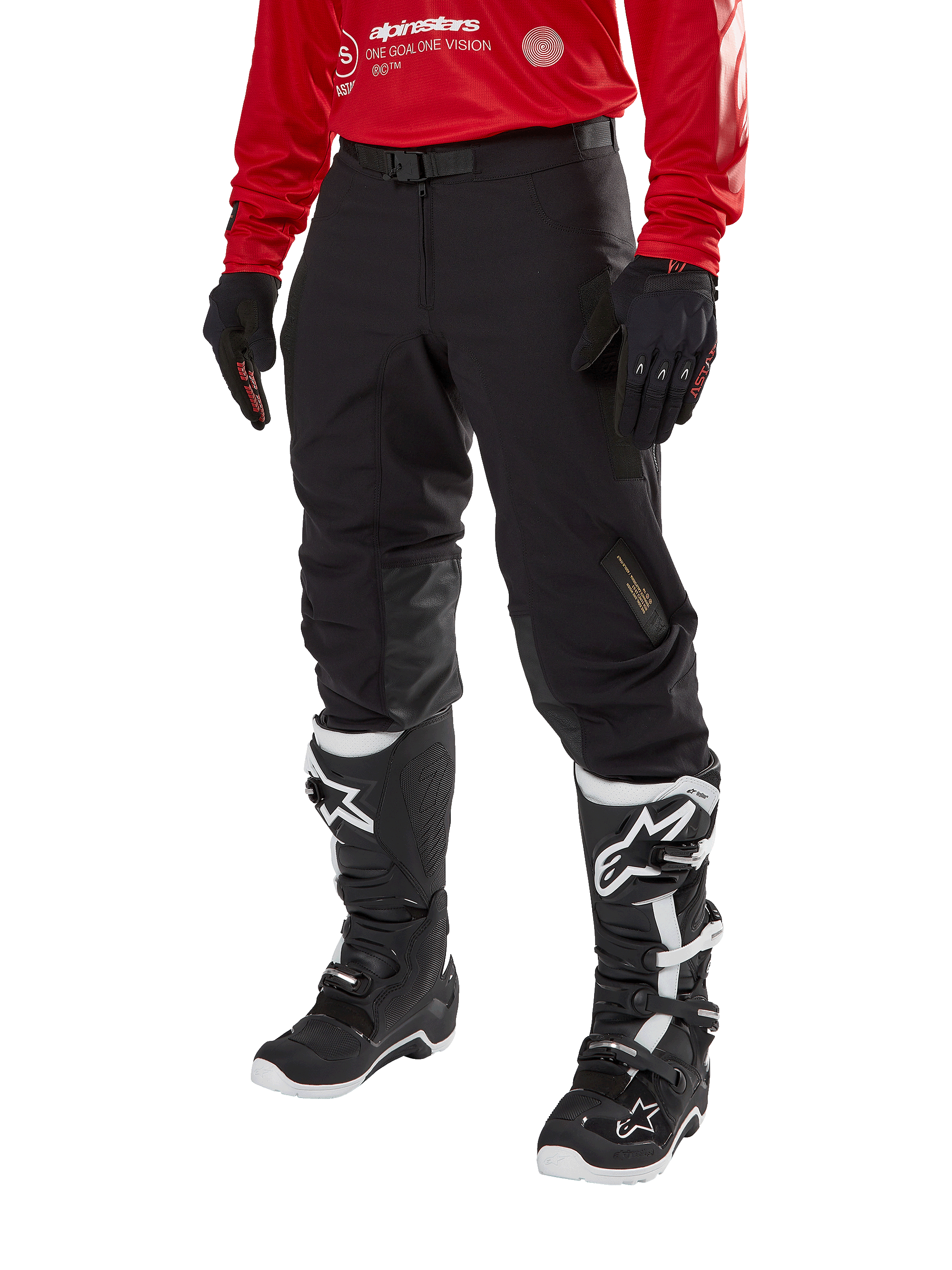 Alpinestars Techdura Hose, schwarze Offroad-Motorradhose, kombiniert mit einem roten Langarm-Trikot und schwarz-weißen Motocross-Stiefeln, mit robuster Stretch-Polyamid-Konstruktion, Lederverstärkungen an den Knieinnenseiten und einem verstellbaren Gürtel mit Schnalle für den Enduro-Einsatz.