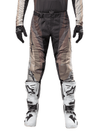 Alpinestars 2024 Techstar Pneuma Pants, Motocross Pants, Dark Sand Iron Dust Gray, worn with matching jersey, black gloves, and white and black boots, featuring SX2 magnetic buckle and Astars branding, durable off-road racing gear