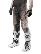Alpinestars 2024 Techstar Pneuma Pants, Motocross Pants, Dark Sand and Iron Dust Gray, worn with white and black boots and black gloves, featuring a wavy pattern with a large star logo, durable gear for off-road racing
