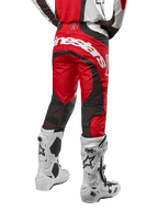 Alpinestars 2024 Techstar Ocuri Hose, Motocross-Hose, Mars Red, Weiß und Schwarz, Rückansicht mit großem weißem Alpinestars-Logo auf dem Gesäß, schwarze Mesh-Belüftungseinsätze, getragen mit weiß-schwarzen Motocross-Stiefeln, athletisches Race-Fit-Design für das Offroad-Fahren