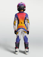 Alpinestars Fluid Drag Jugend-Hose, Motocross-Hose in Blau und Weiß mit gelben Akzenten, Rückansicht in voller Offroad-Montur.