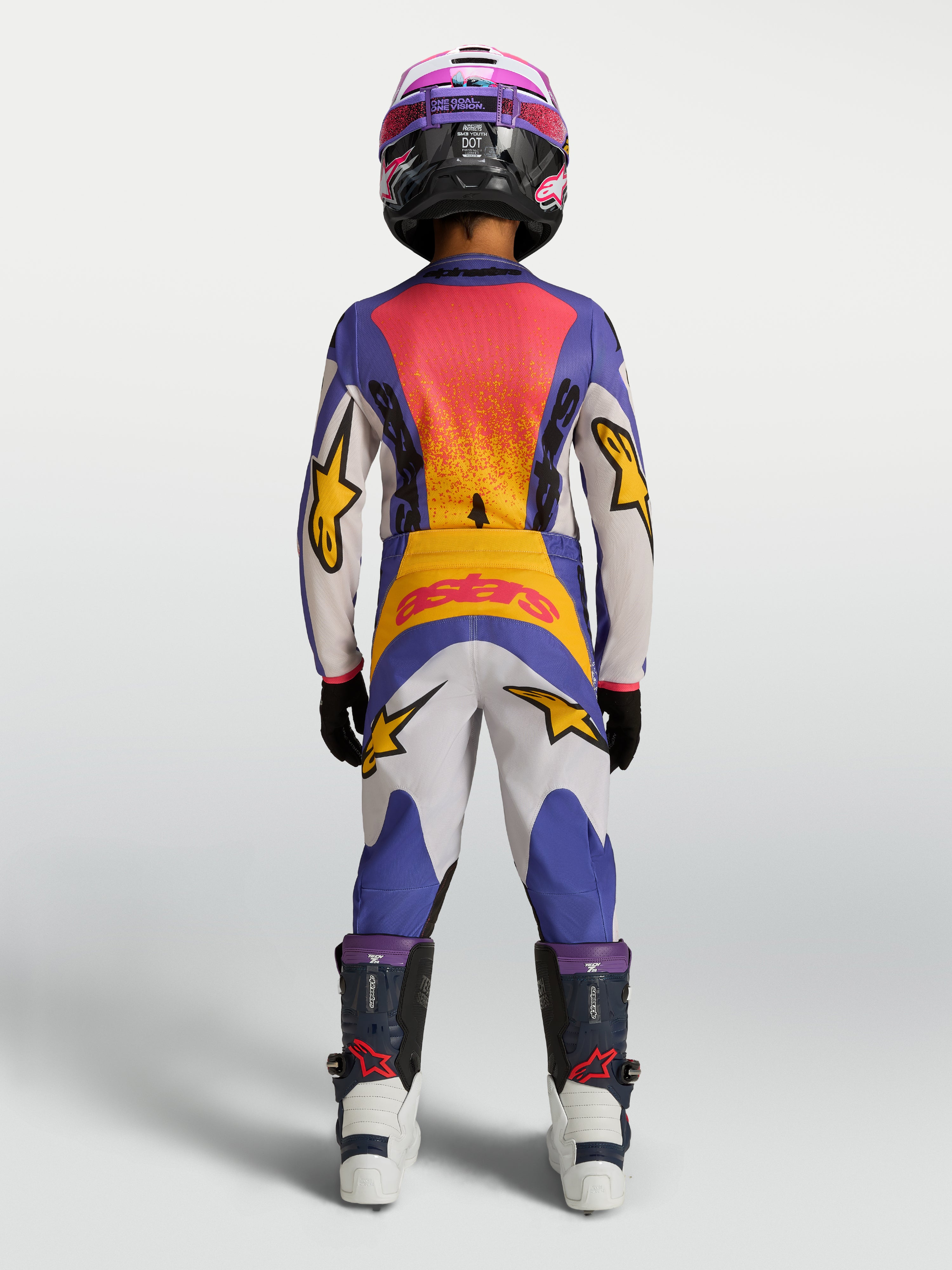 Alpinestars Fluid Drag Jugend-Hose, Motocross-Hose in Blau und Weiß mit gelben Akzenten, Rückansicht in voller Offroad-Montur.