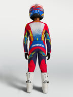 Alpinestars Jugend Fluid Drag Hose 2027, MX-Hose, Blau und Rot, Rückansicht mit Trikot, Helm und weißen Stiefeln.