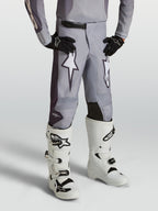 Alpinestars Fluid Jugend-Hose Amber, sandgraue Motocross-Hose für Kinder mit weißen Sterngrafiken und verstärkten Einsätzen.