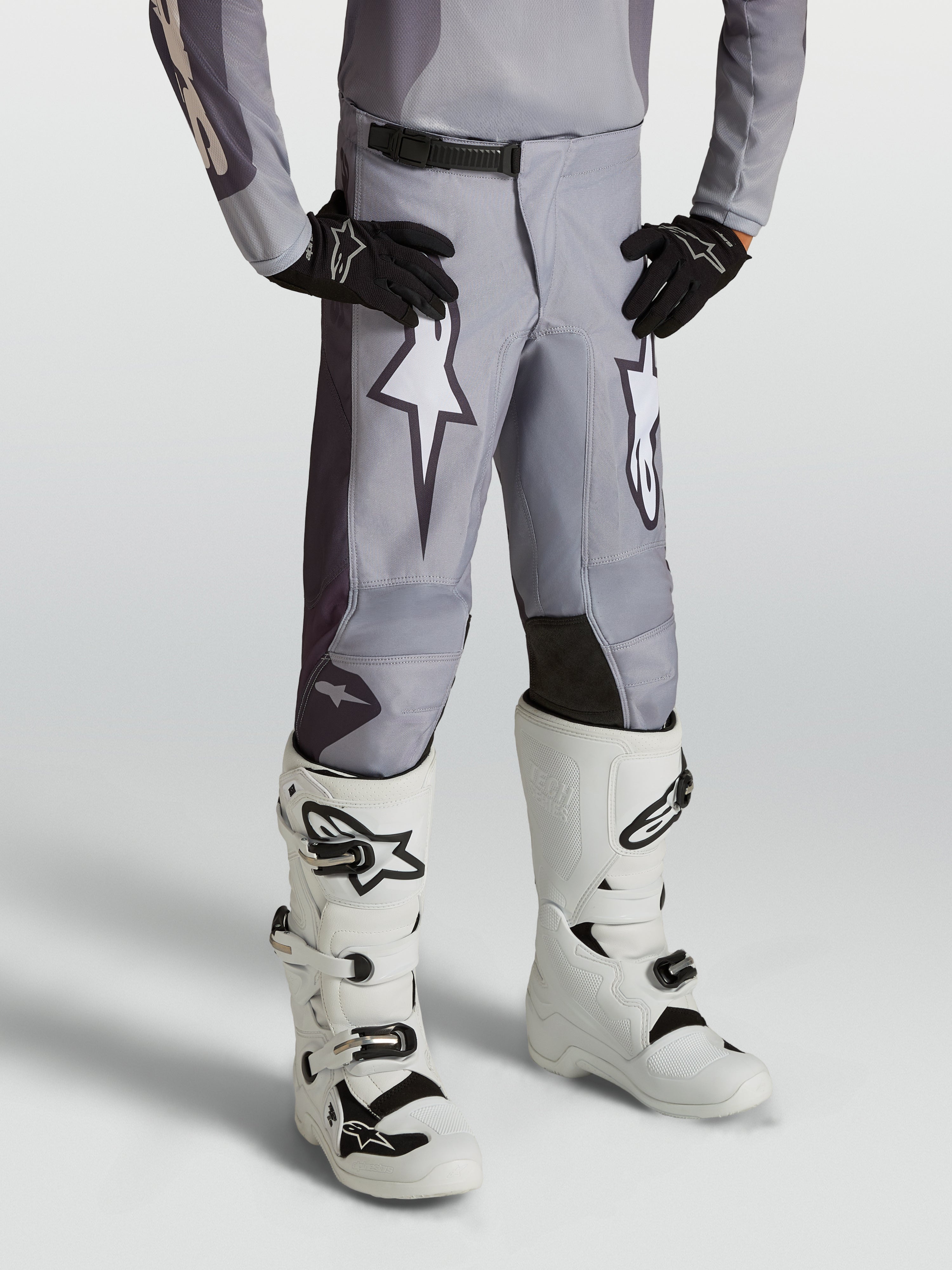 Alpinestars Fluid Jugend-Hose Amber, sandgraue Motocross-Hose für Kinder mit weißen Sterngrafiken und verstärkten Einsätzen.