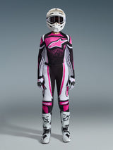 Motocross rider wearing complete racing gear, Black and fuchsia jersey with white accents, Alpinestars 2026 Woman Stella Techstar Nomur Pants in Black White and Fuchsia, white helmet with goggles, white and black boots, black and white gloves, coordinated outfit for women's off-road racing