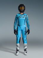 Alpinestars 2026 Stella Fluid Apex Gear Set, Damen-Motocross-Jersey und Hose, Blau und Schwarz, mit großem Sternen-Logo auf der Brust, getragen mit schwarzem Helm, getönter Brille und weißen Stiefeln mit schwarzen Akzenten, komplettes Offroad-Rennoutfit