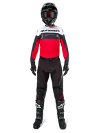 Motocross-Fahrer im Alpinestars Pro-Dura Trikot in Schwarz, Bright Red und Weiß, kombiniert mit schwarzer Hose, schwarzen Stiefeln und einem schwarzen Helm, komplette Offroad-Rennausrüstung.