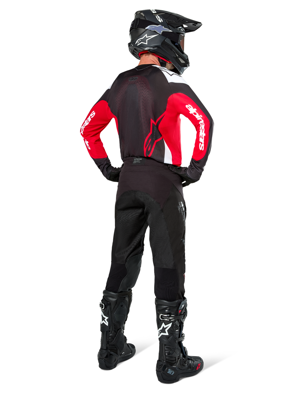 Motocross-Fahrer in der Rückansicht, Alpinestars Pro-Dura Jersey in Schwarz, Hellrot und Weiß, kombiniert mit schwarzer Motocross-Hose, Helm und Stiefeln, zeigt das Rückendesign und die Ärmellogos, abgestimmte Offroad-Rennausrüstung.