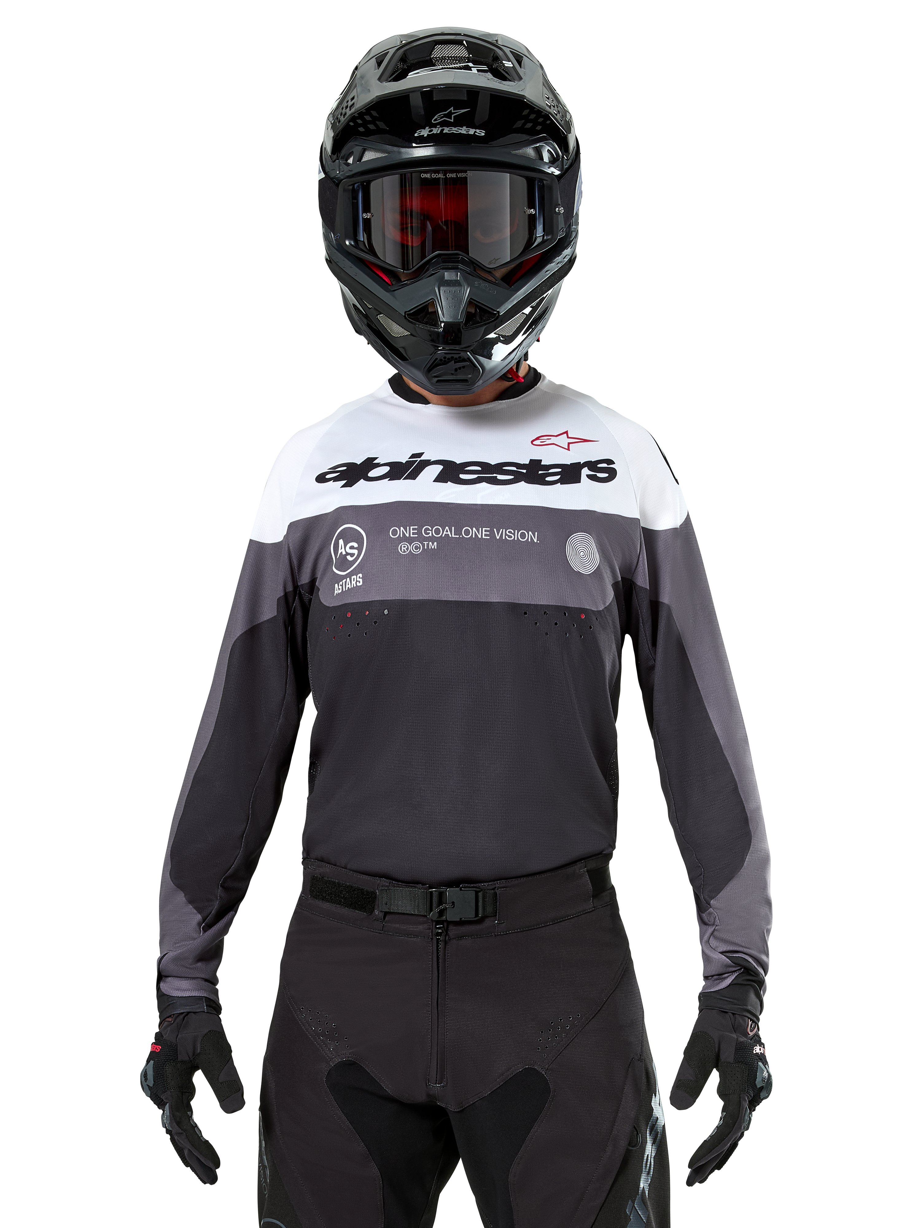 Motocross-Fahrer im Alpinestars Pro-Dura Jersey in Black Magnet White, langärmliges Performance-Oberteil mit weißen und grauen Farbblöcken, kombiniert mit schwarzem Helm und Schutzbrille, Alpinestars-Branding und „ONE GOAL ONE VISION“-Slogan, Offroad-Motorrad-Rennbekleidung