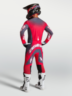 Alpinestars Supertech Hiten AFD Trikot und Gear Set, Motocross-Outfit in Rot Fluo und Grau, Rückansicht am Model.